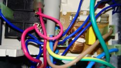Zbliżenie na podzespoły elektroniczne z przewodami wewnątrz kuchenki mikrofalowej Panasonic.