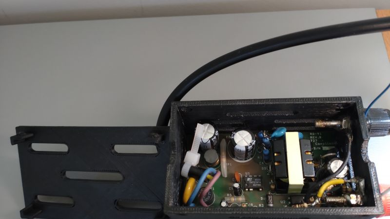 Zdjęcie otwartej obudowy z komponentami elektronicznymi w środku.