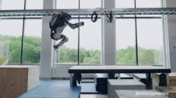 Robot Boston Dynamics skacze pomiędzy platformami w przestrzeni treningowej.