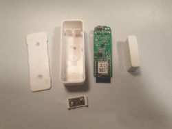 Disassembled door sensor showing circuit board and casing.