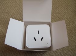 Electrical Plug in a Box White electrical plug with three holes in an open cardboard box.