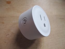 Smart Plug with Button White smart plug with a circular button on the side.