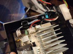 Zdjęcie wnętrza urządzenia z widocznymi przewodami i elementami elektronicznymi.