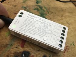 Miboxer 3 in 1 LED controller with green light on a wooden surface.