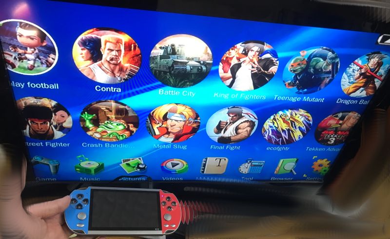 Retro game menu on a screen, with an X12 handheld console in hand featuring blue and red controllers
