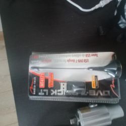 Pudełko z tunerem USB DVB-T i anteną umieszczone na ciemnym stole.