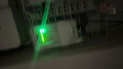 Zamazane zdjęcie urządzenia z zielonymi diodami w szafce elektrycznej.