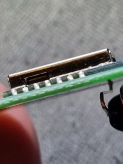 Close-up of a circuit board with a row of pins and a connector.