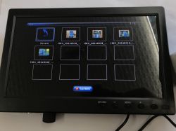 Small black monitor showing a USB photo browser grid with thumbnails