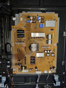 Płyta główna elektroniki telewizora Sony na tle czarnej obudowy.