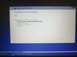 Ekran instalatora systemu Windows pokazujący postęp instalacji na poziomie 18%.