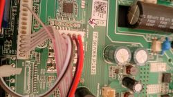 Close-up of a PCB with wires in a connector, electrolytic capacitors, and the label “TP.SK706S.PC822”.