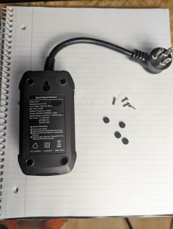 Smart Plug Treatlife DP10 on a Notebook Treatlife DP10 smart plug on a notebook with unscrewed screws and rubber pads.
