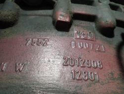 Widok skrzyni biegów ze sprzęgłem z oznaczeniami numerów seryjnych i innych symboli na powierzchni.