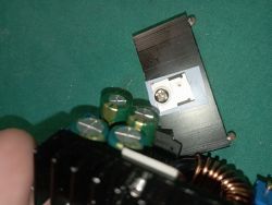 Close-up of a damaged electronic circuit with a visible transistor and coils.