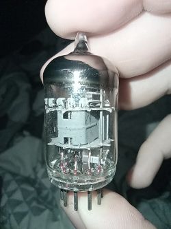 Lampa elektronowa w szklanej obudowie trzymana w palcach