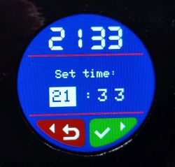 Okrągły ekran TFT z czasem 21:33 i menu „Set time” oraz przyciskami cofania i zatwierdzenia