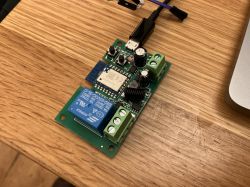 Relay Board with CB3S Module Small relay board with CB3S module on a wooden table.