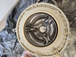 Widok bębna pralki Hoover w plastikowej obudowie, przygotowany do montażu nowego fartucha.