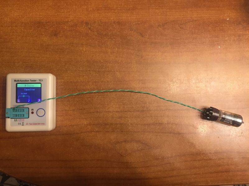 Tester TC1 z połączoną lampą elektronową za pomocą zwoju przewodów na drewnianym tle.