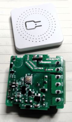 Two electronic components: a white plastic casing and a green circuit board with electronic parts.