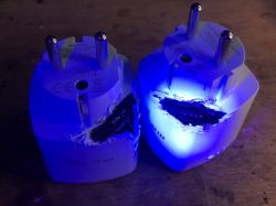 Damaged Electrical Sockets with Blue Light Two electrical sockets with visible damage and glowing blue light.