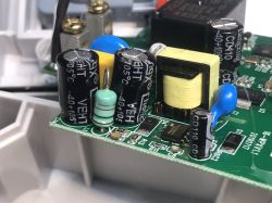 Close-up of electronic components on a PCB from a WiFi socket, including capacitors, a resistor, and a transformer.