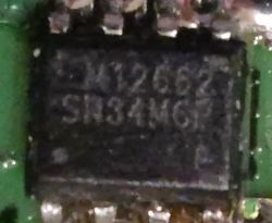 Makrofotografia układu scalonego SMD na zielonej płytce PCB, z widocznym napisem „SR3A4G”.