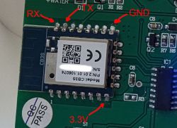 Electronic module on a board with labeled RX, TX, GND, and 3.3V pins