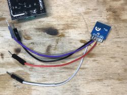 FL_M99 Module with Wires Orange FL_M99 module with attached wires on a wooden surface.