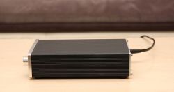 New Case for Headphone Amplifier Black headphone amplifier with a new, larger case on a wooden table.
