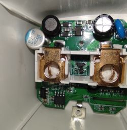 Inside of electrical socket with replaced capacitor View of the inside of an electrical socket with a replaced 470μF/6.3V electrolytic capacitor and electronic components on a PCB.