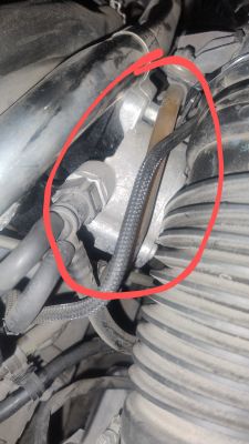 Fragment silnika samochodowego z zaznaczonym obszarem w czerwonym kółku.