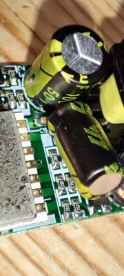 Close-up view of a circuit board with two large electrolytic capacitors mounted vertically.