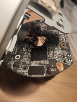 Zbliżenie na wnętrze rozebranego urządzenia elektronicznego pokazujące płytkę drukowaną.