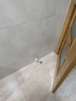 Image of sensor installation on a tiled wall with an open door.