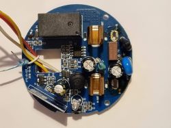 Round blue PCB with relay, capacitors, and a side bundle of colored wires