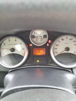 Widok deski rozdzielczej samochodu z prędkościomierzem, obrotomierzem i wyświetlaczem przebiegu.