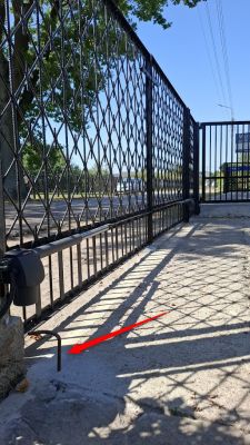 Metalowy odbojnik przy słupku bramy przesuwnej na betonowym podłożu
