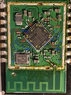 Close-up of a PCB with a QFN IC and a printed antenna, with colored handwritten trace annotations.