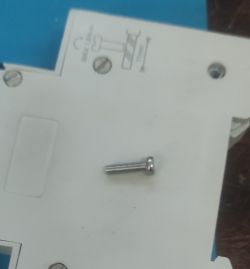 Small M2.5x10 screw on an electrical device background.
