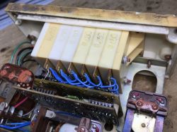 Inside an electrical device with multiple relays, circuit boards, and blue wiring