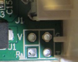 Close-up of a circuit board with four test holes labeled as V, R, C, and T.
