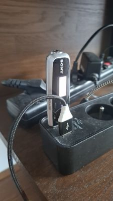 Odtwarzacz MP3 Sony podłączony do ładowarki USB.