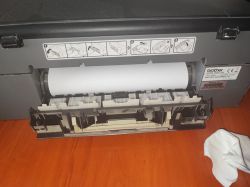 Brother Printer with Paper Feeding Issue Front of Brother printer with paper tray open and a sheet of paper visible.