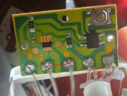 Zbliżenie na płytkę drukowaną z elementami elektronicznymi i oznaczeniami.