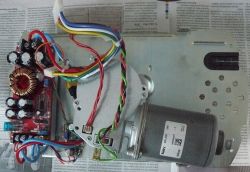 Ansicht eines Garagentorantriebs mit bunten Kabeln und Komponenten auf einer Metallplatte.