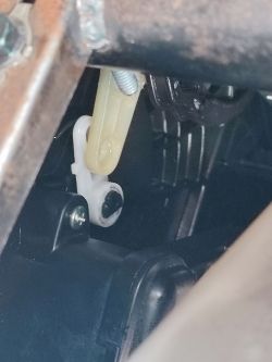 Widok mechanizmu klapy nawiewu za schowkiem w Kia Carnival