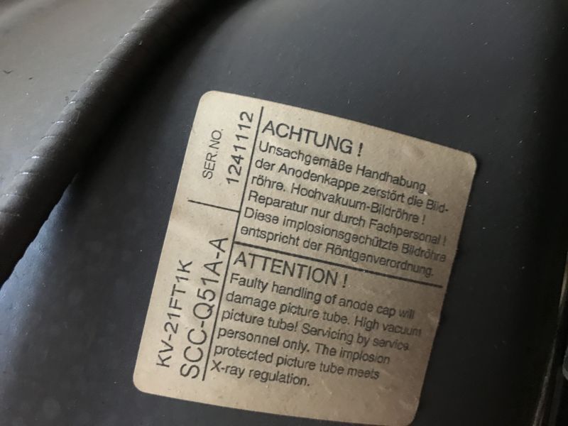 Tabliczka znamionowa telewizora Sony Trinitron z ostrzeżeniem w dwóch językach