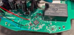 Close-up of a circuit board with relay, capacitors, and colored wires.